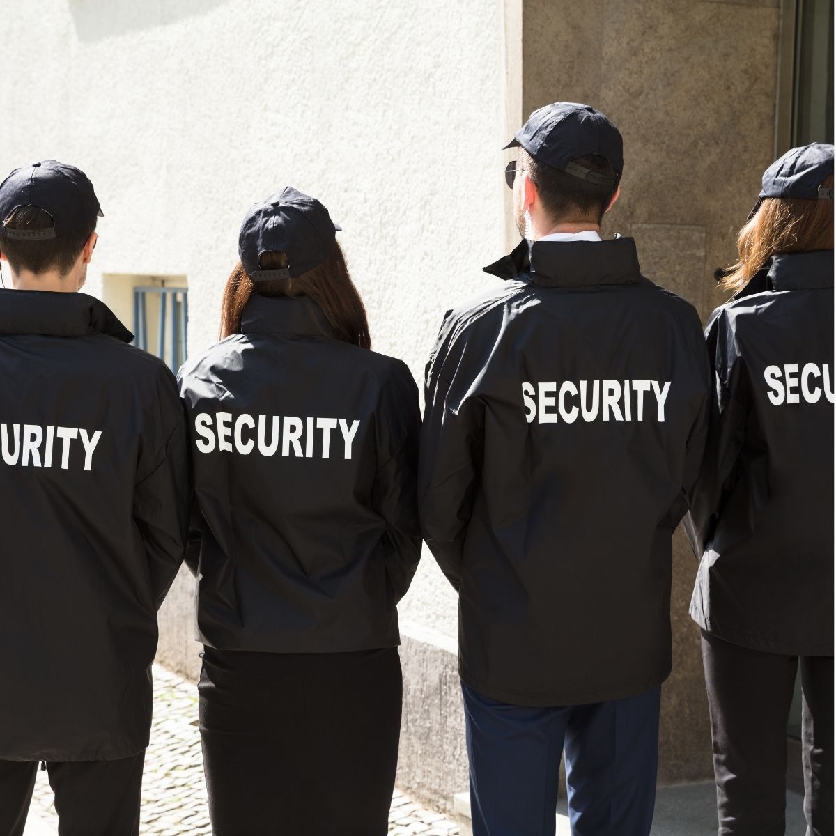 Agent de sécurité en uniforme vu de dos, portant un gilet avec l’inscription. Agent de sécurité en uniforme vu de dos.