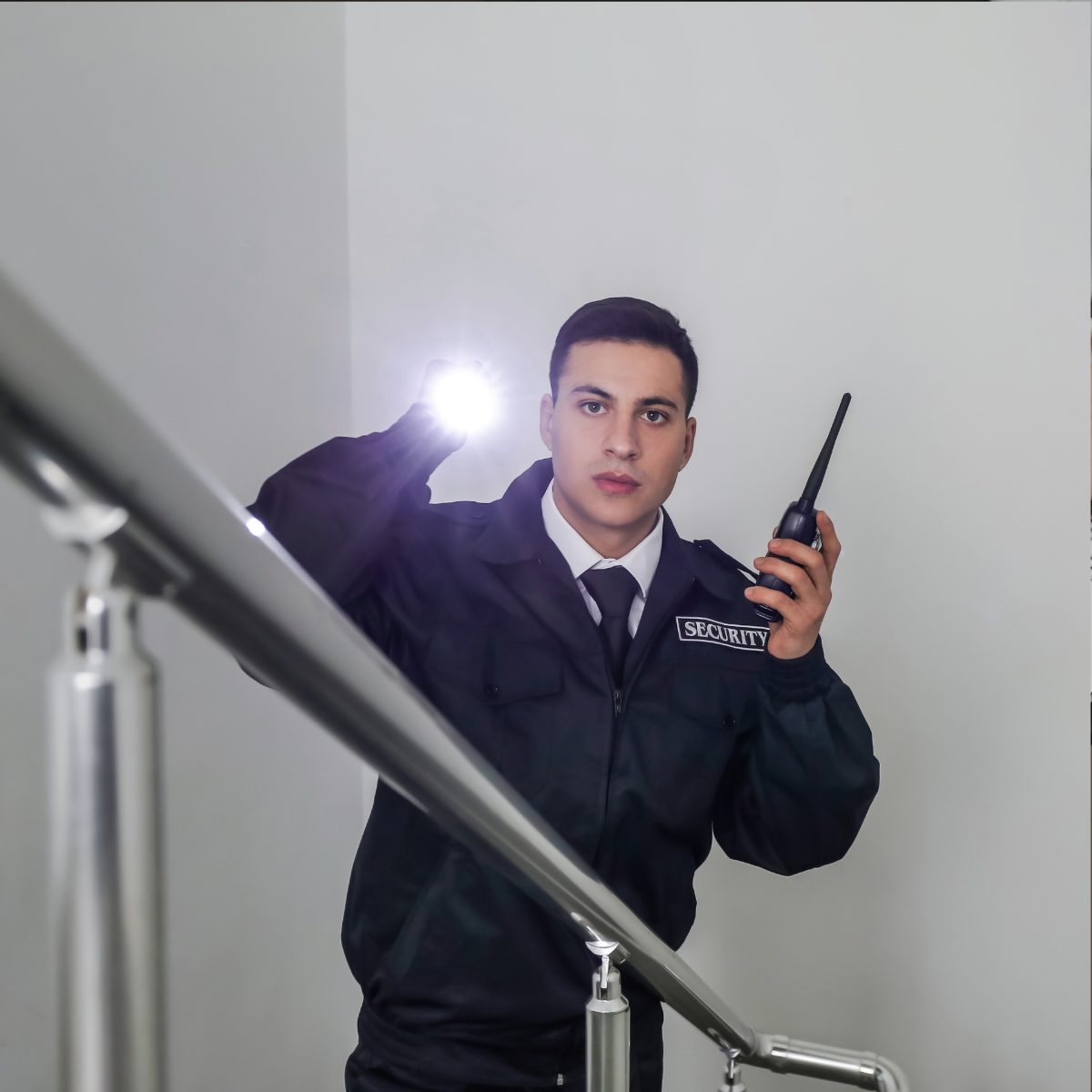 Agent de sécurité privé effectuant sa ronde, lampe torche en main.