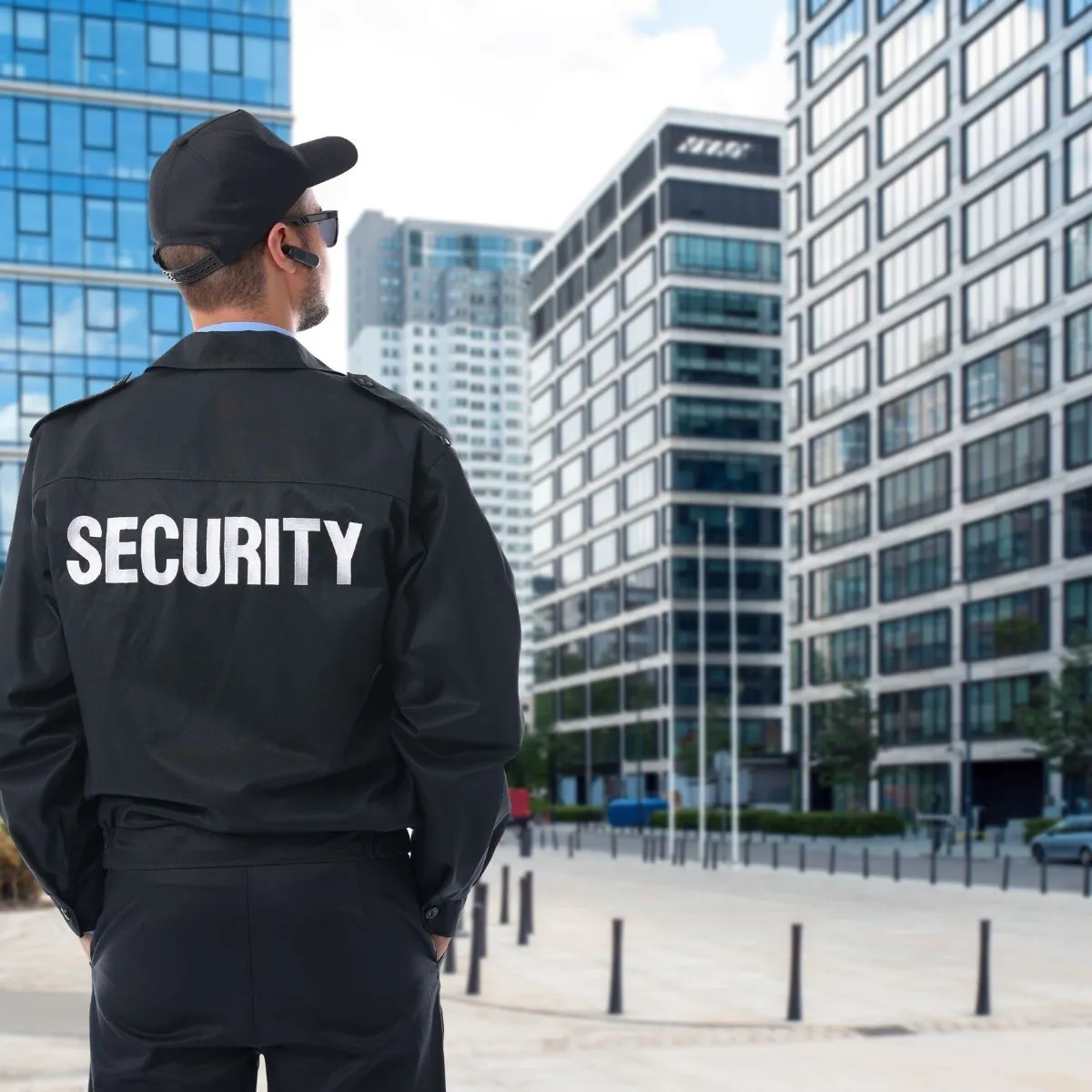 Agent de sécurité en uniforme debout devant un bâtiment.
