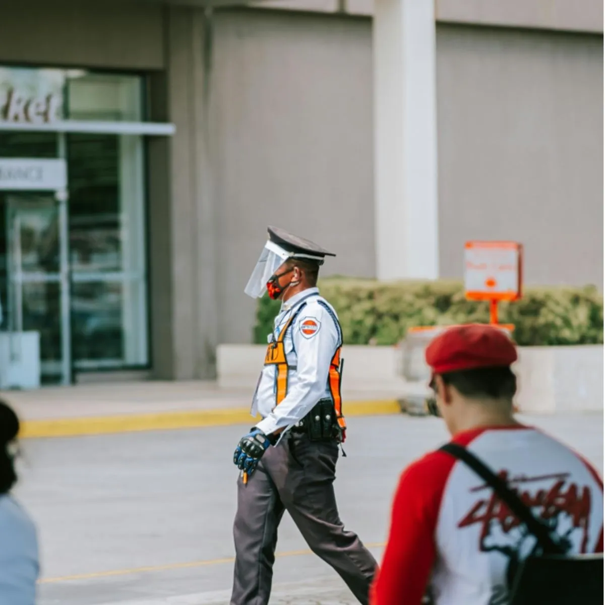 Agent de sécurité privé en uniforme marchant à l’extérieur.