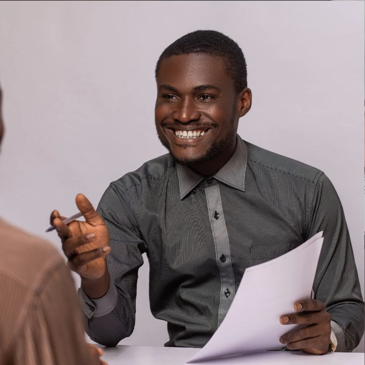 Un recruteur en entretien avec une candidate, tenant un dossier.